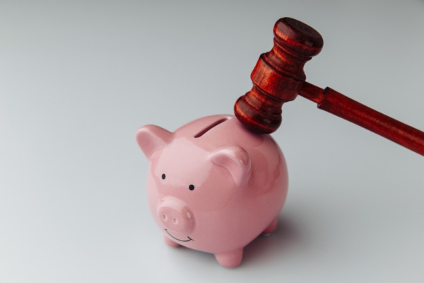 Judge gavel and piggy bank depicting legal and financial consequences of cracked windshield