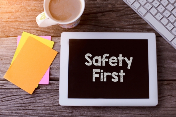 smart tablet with Safety First on display beside a cup of coffee and colored papers