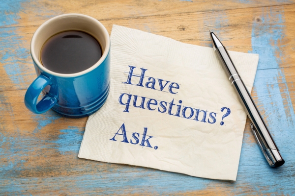 have questions ask written on table napkin beside a coffee mug depicting front & rear windshield replacement FAQs