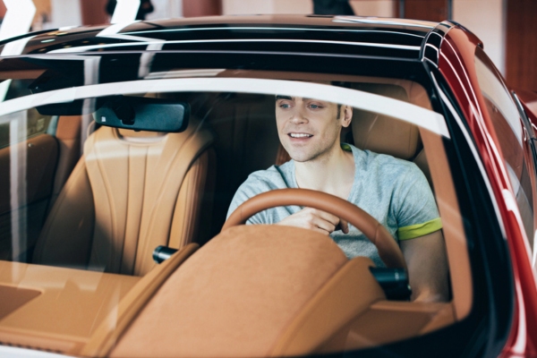 man sitting inside a car with a clean windshield depicting windshield features