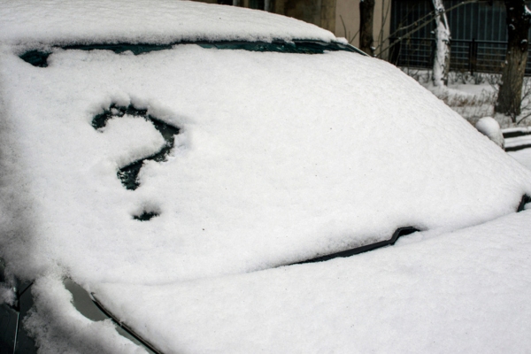 A car under the snow and a question mark in the windshield