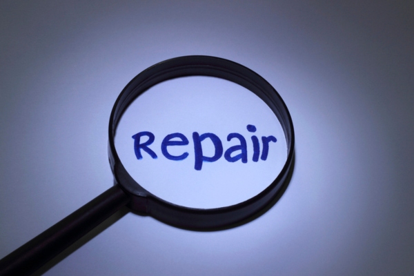 repair word written on paper highlighted by a magnifying glass