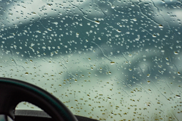 image of a windshield with water droplets taken from inside the car