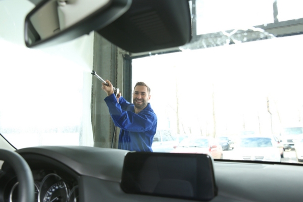 professional autoglass worker cleaning the windshield