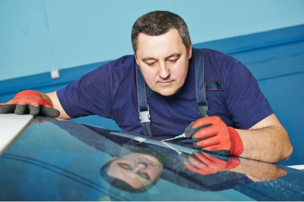 man repairing windshield crack