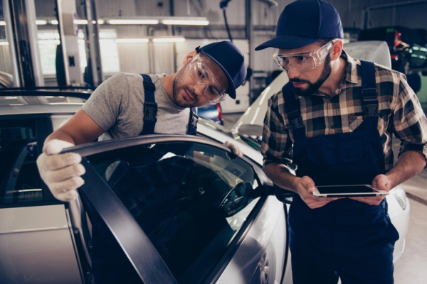 Auto Glass Technicians Assessing Car Glass Damage