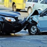 image of 2 cars with broken bumpers after a head on collision