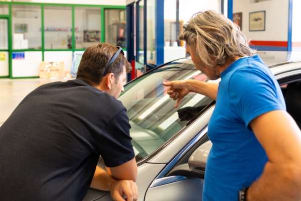 vehicle owner inspecting newly installed windshield