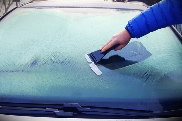man taking off ice from windshield