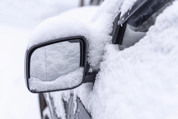 side mirror with snow on top and on glass