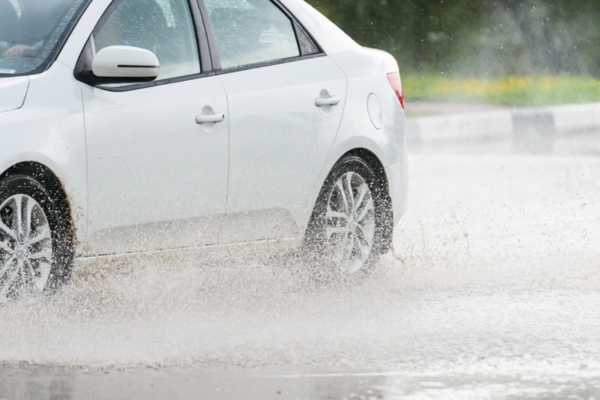 car driving on a puddle after a rainfall