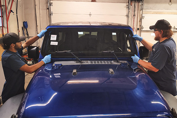 Ebervale, PA technicians performing ADAS windshield calibration on a blue vehicle