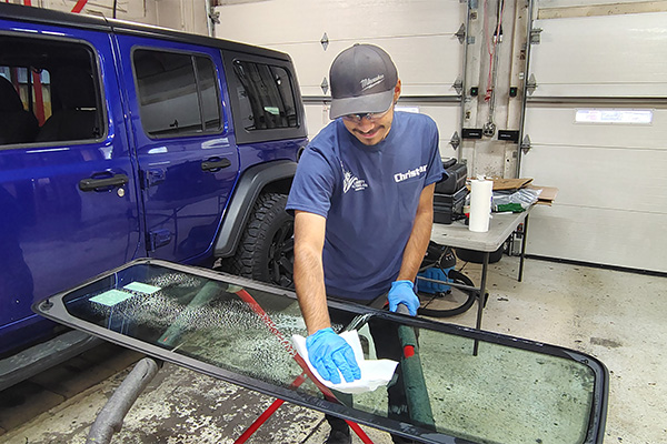 Ebervale, PA technician cleaning a windshield in an auto glass service shop